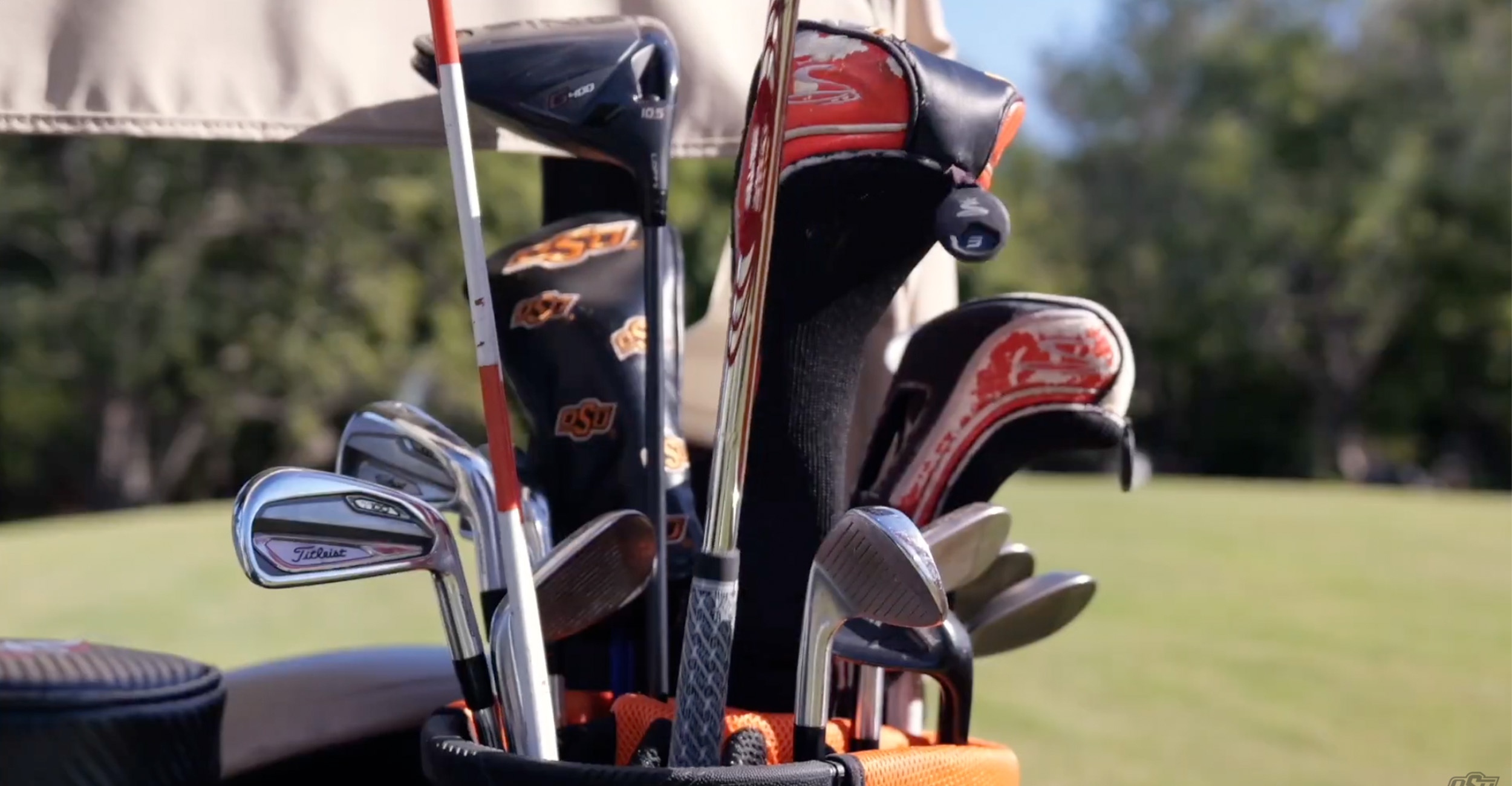 Heckenkemper banner Bag of OSU golf clubs in the back of a golf cart