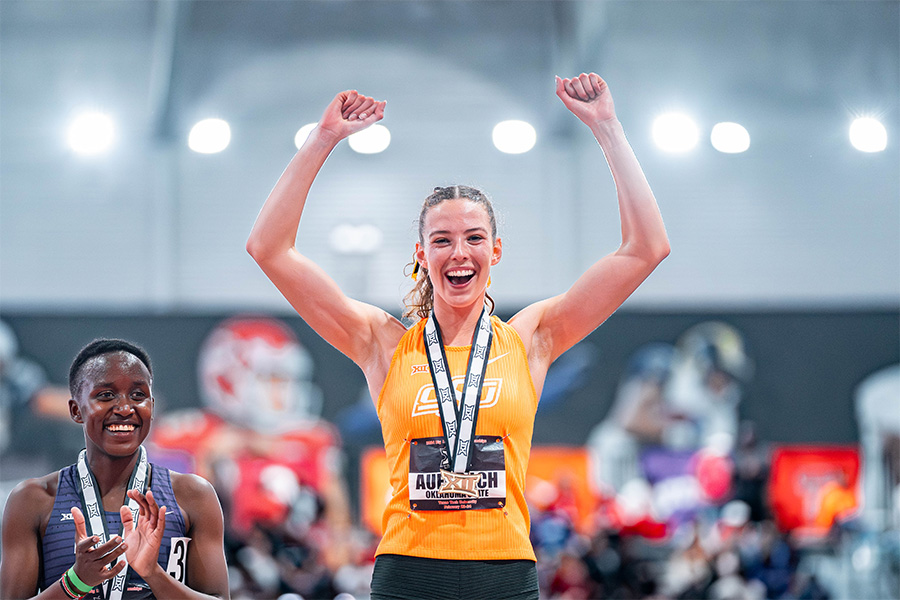 Two athletes celebrate while at the winner's podium following a race. Two athletes celebrate while at the winner's podium following a race.