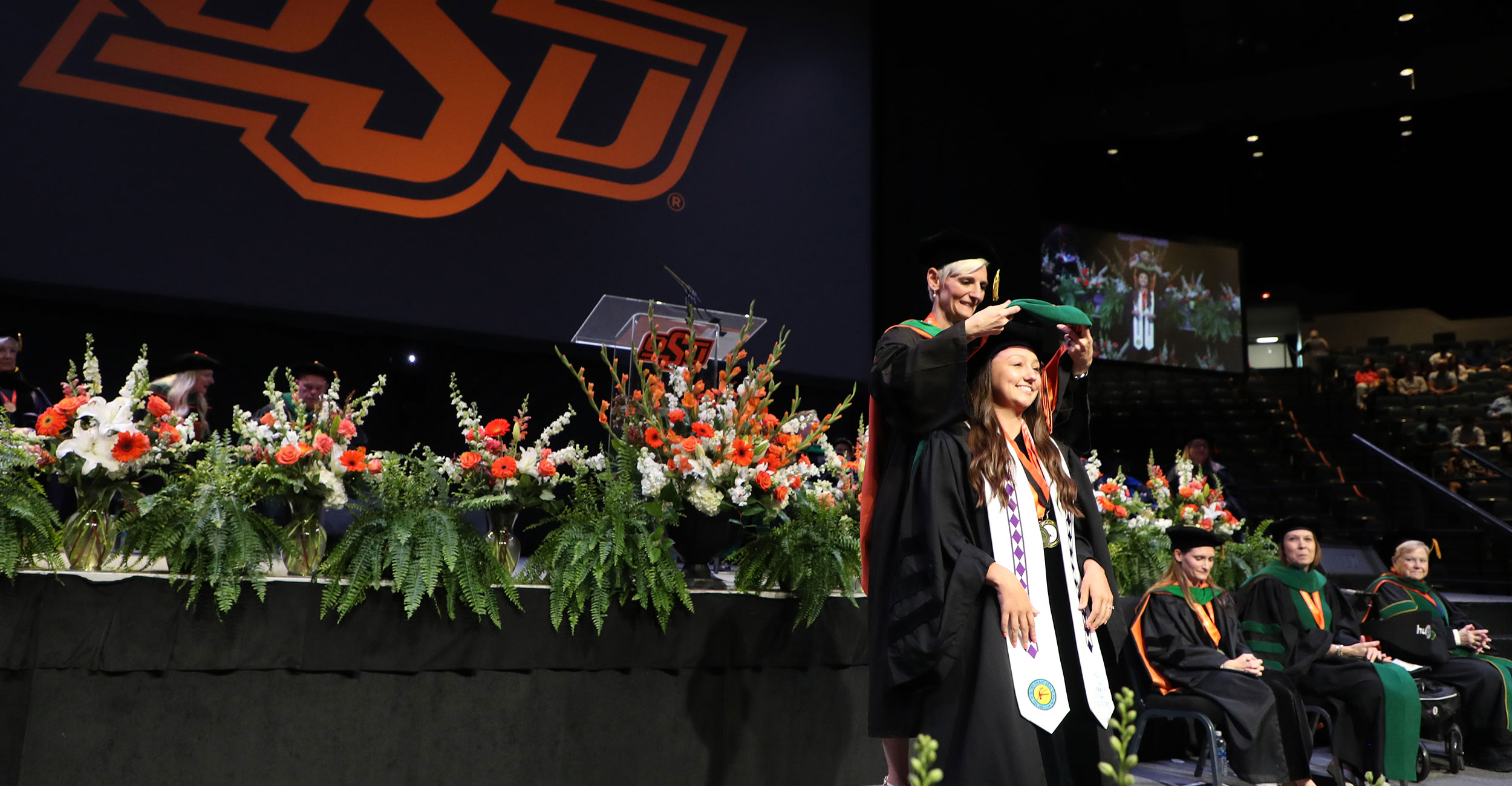 Choctaw Nation of Oklahoma citizen Caitlin Cosby is hooded by Dr. Natasha Bray during the OSU College of Osteopathic Medicine commencement ceremony in Tulsa on Thursday, May 16, 2024. Cosby was among the inaugural class of students from the OSU College of Osteopathic Medicine at the Cherokee Nation in Tahlequah, Oklahoma. Choctaw Nation of Oklahoma citizen Caitlin Cosby is hooded by Dr. Natasha Bray during the OSU College of Osteopathic Medicine commencement ceremony in Tulsa on Thursday, May 16, 2024. Cosby was among the inaugural class of students from the OSU College of Osteopathic Medicine at the Cherokee Nation in Tahlequah, Oklahoma.