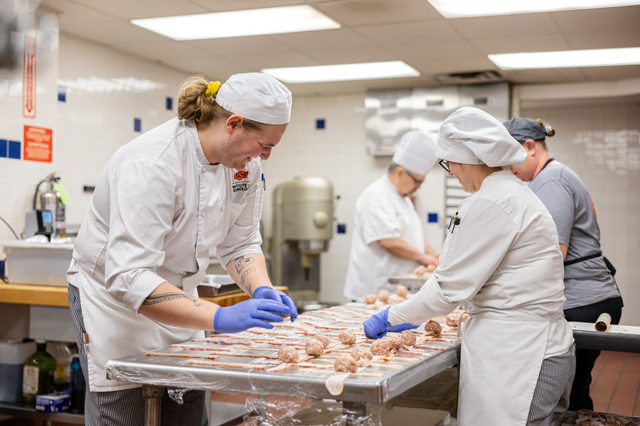 Chefs go to work in the OSUIT kitchen and help prepare bacon wrapped meatballs