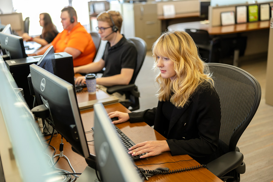 Students gain hands-on experience answering calls in an Information Technology office
