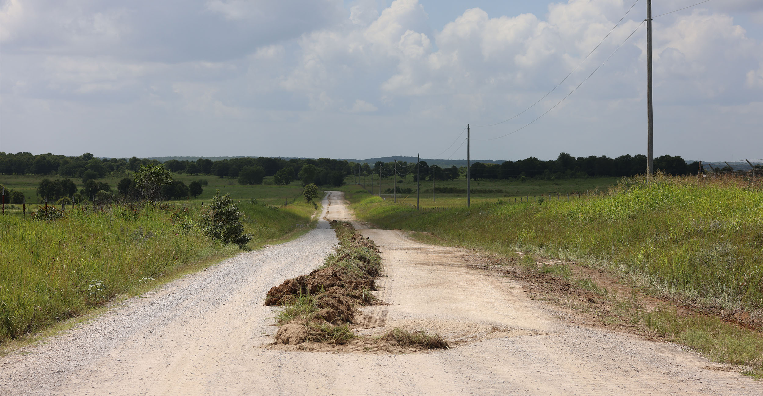 Shown is grass on a rural roadway that was removed from the side ditches by a motor grader. The grass was then cleared by an additional vehicle. Shown is grass on a rural roadway that was removed from the side ditches by a motor grader. The grass was then cleared by an additional vehicle.