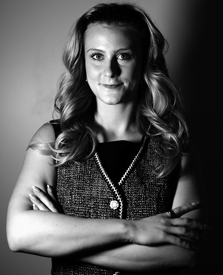A black and white photo of Ainsley Kyle with her arms crossed.