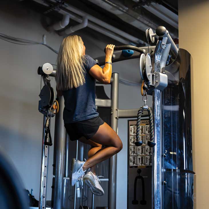 a female police officer wearing workout clothes performs pull-ups a female police officer wearing workout clothes performs pull-ups